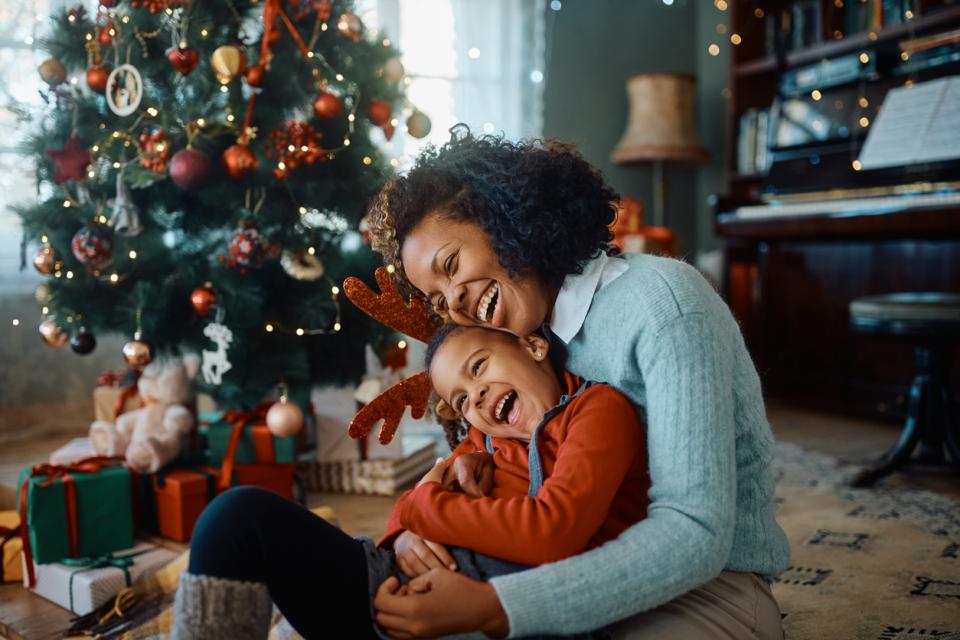 Mère et son enfant devant le sapin