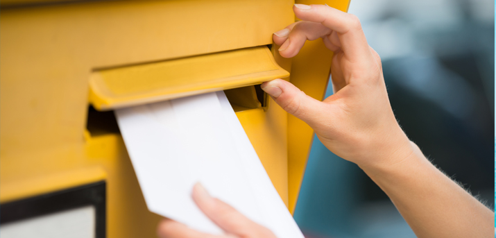 personne qui met son courrier dans une boîte aux lettres