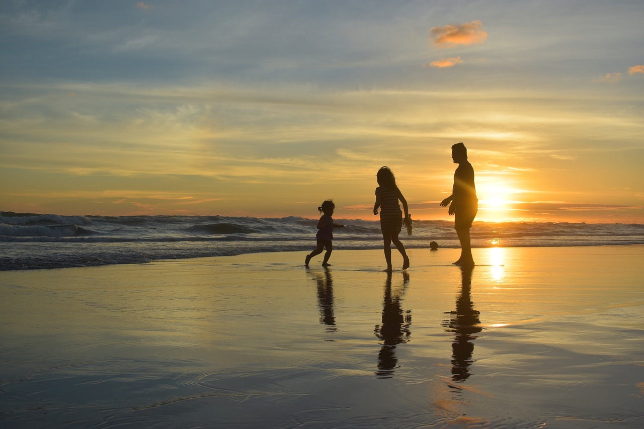Couple avec un enfant sur la plage et coucher de soleil"