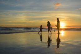 Couple sur la plage avec un enfant et coucher de soleil
