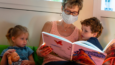 nounou lisant une histoire à des enfants
