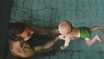 bébé qui nage avec son papa