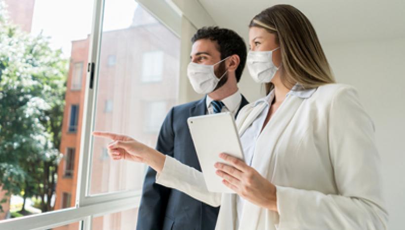 agent immobilier devant une fenêtre 