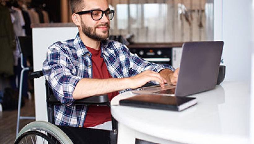 homme en fauteuil roulant en télétravail